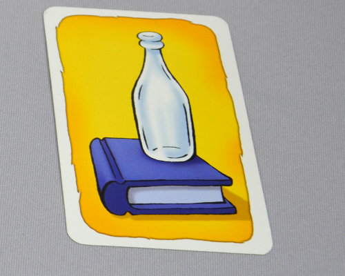 Spielkarte Geistesblitz: eine weiße Flasche steht auf einem blauen Buch