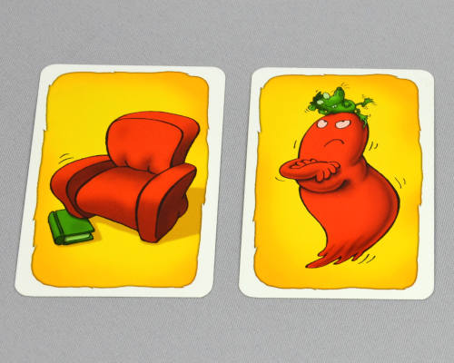 Spielkarten vom Spiel Geistesblitz, zu sehen sind ein roter Sessel mit einem grünen Buch und auf der zweiten Karten eine roter Geist mit einer grünen Maus auf dem Kopf