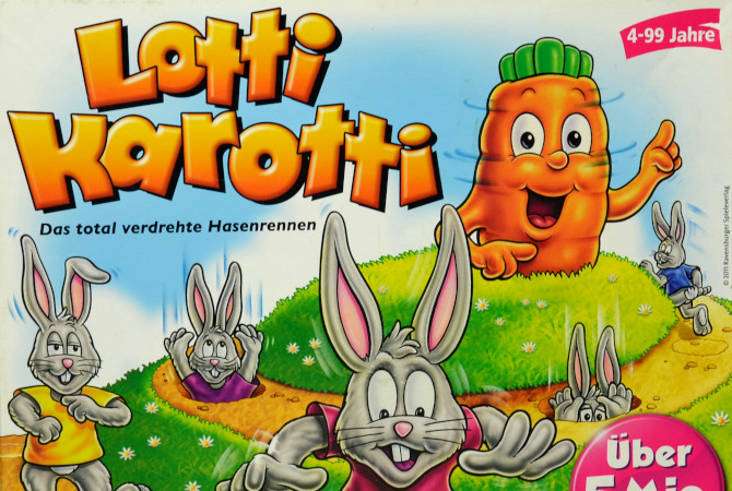 Lotti Karotti Spielkarton gezeichnete Hasen, die in Löcher stecken, im Hintergrund eine Möhre mit Augen und Armen